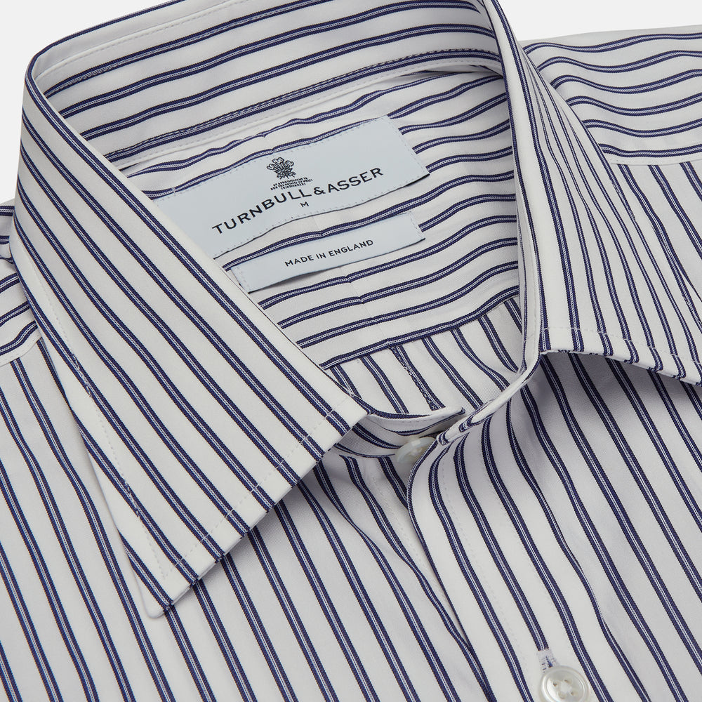 The Turnbull & Asser Navy Stripe Weekend Fit Shirt features a Derby collar, vertical navy and white stripes, 1-button cuffs, a chest pocket, and a regular fit, shown laid flat against a white background.