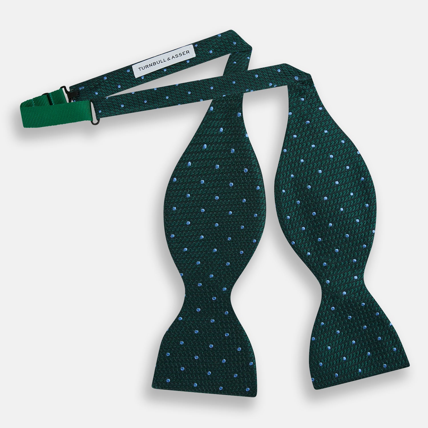 View 2 of product The Turnbull & Asser Forest Green and Sky Blue Spot Houndstooth Silk Bow Tie features a textured pattern with light blue polka dots, shown against a plain white background.