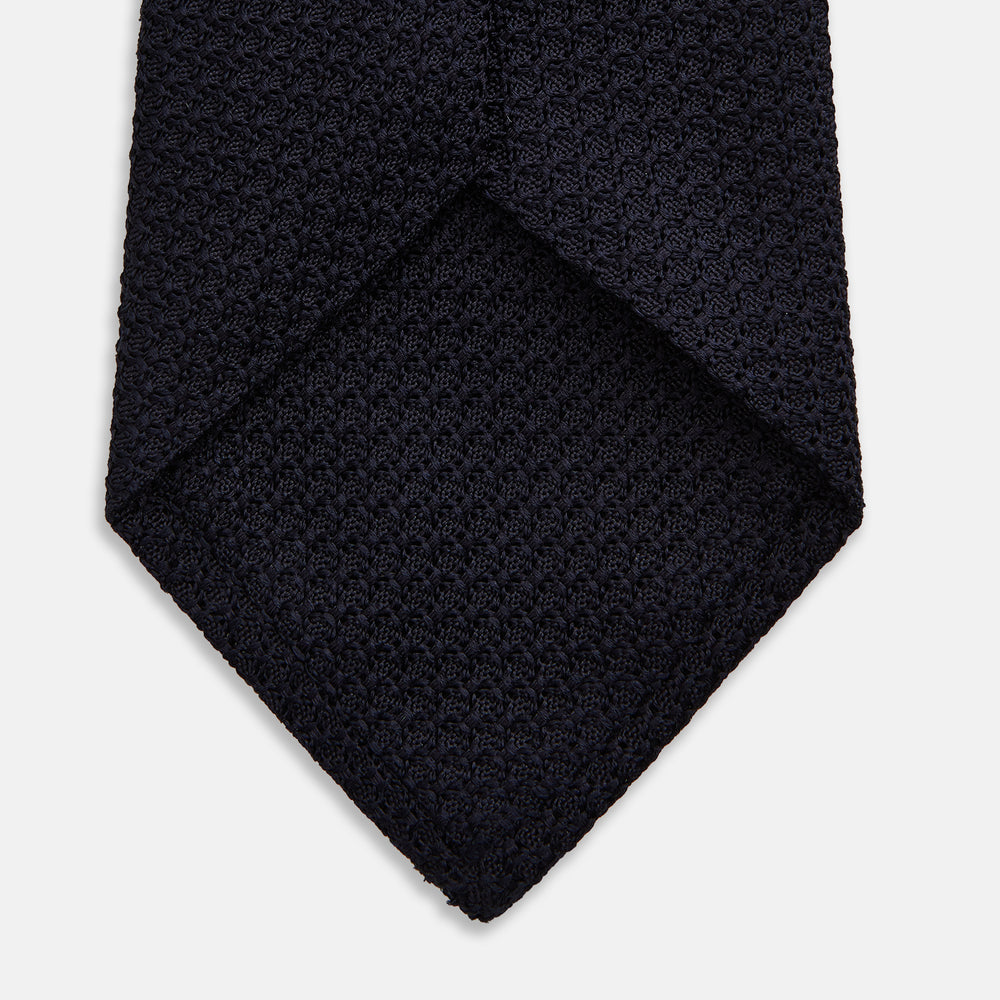 The Turnbull & Asser Midnight Blue Knitted Tie, elegantly textured and displayed on a white background, is a versatile addition to any gentleman's wardrobe.