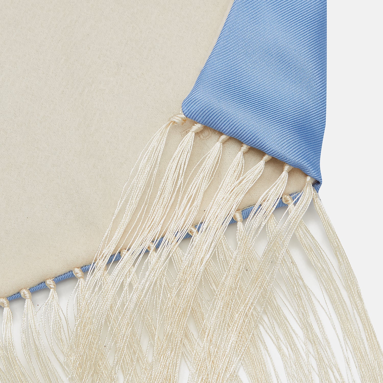 View 3 of product The Turnbull & Asser GGSC3128 5665 06 OS is a blue paisley silk scarf with ornate gold designs, solid light blue ends, and cream fringes. Shown laid flat with one end folded, it highlights its luxurious style.