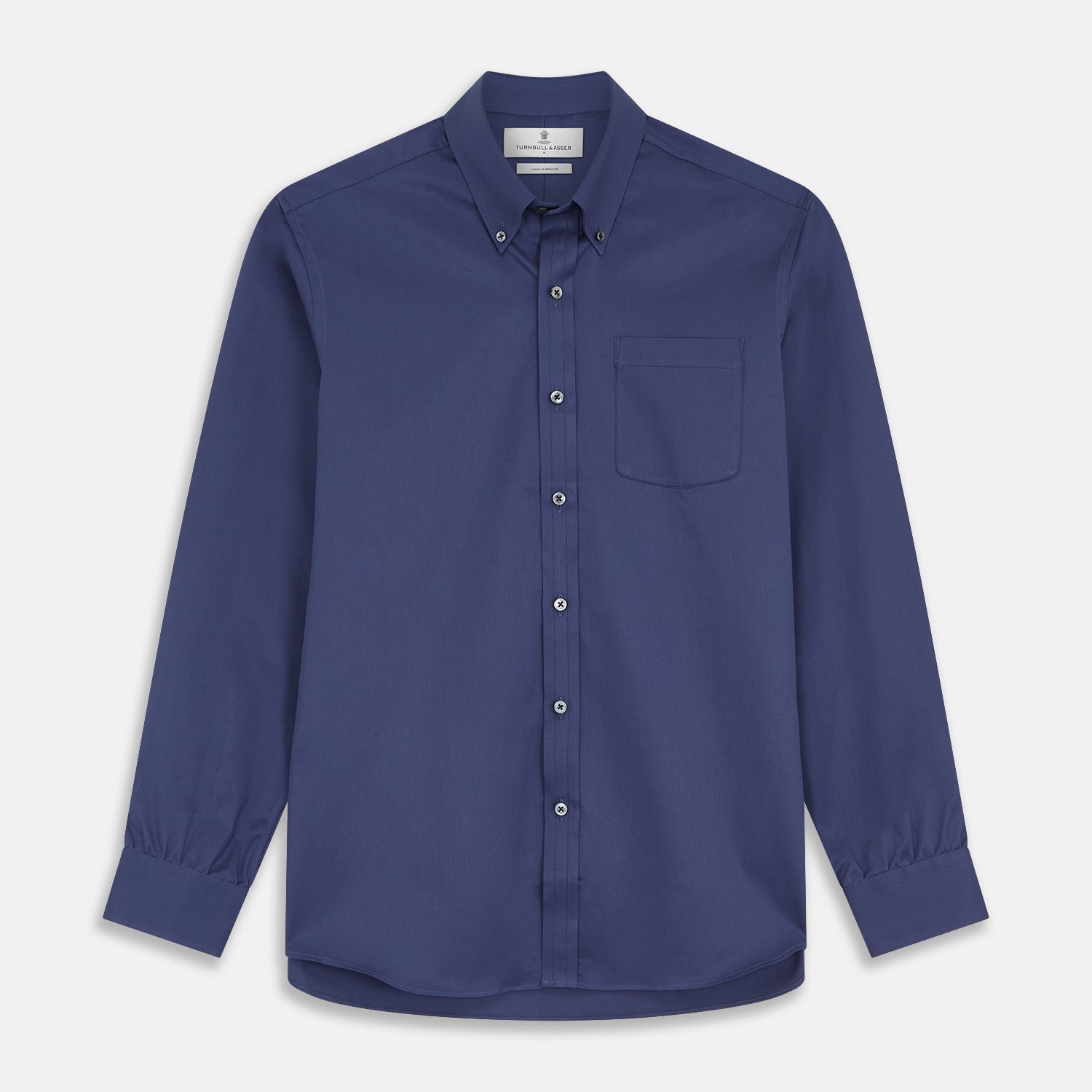View 1 of product The Blue Piece Dyed Weekend Fit Suffolk Shirt by Turnbull & Asser features a button-down Dorset collar, chest pocket, white buttons, and long sleeves in classic navy, laid flat against a white background.