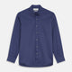 The Blue Piece Dyed Weekend Fit Suffolk Shirt by Turnbull & Asser features a button-down Dorset collar, chest pocket, white buttons, and long sleeves in classic navy, laid flat against a white background.