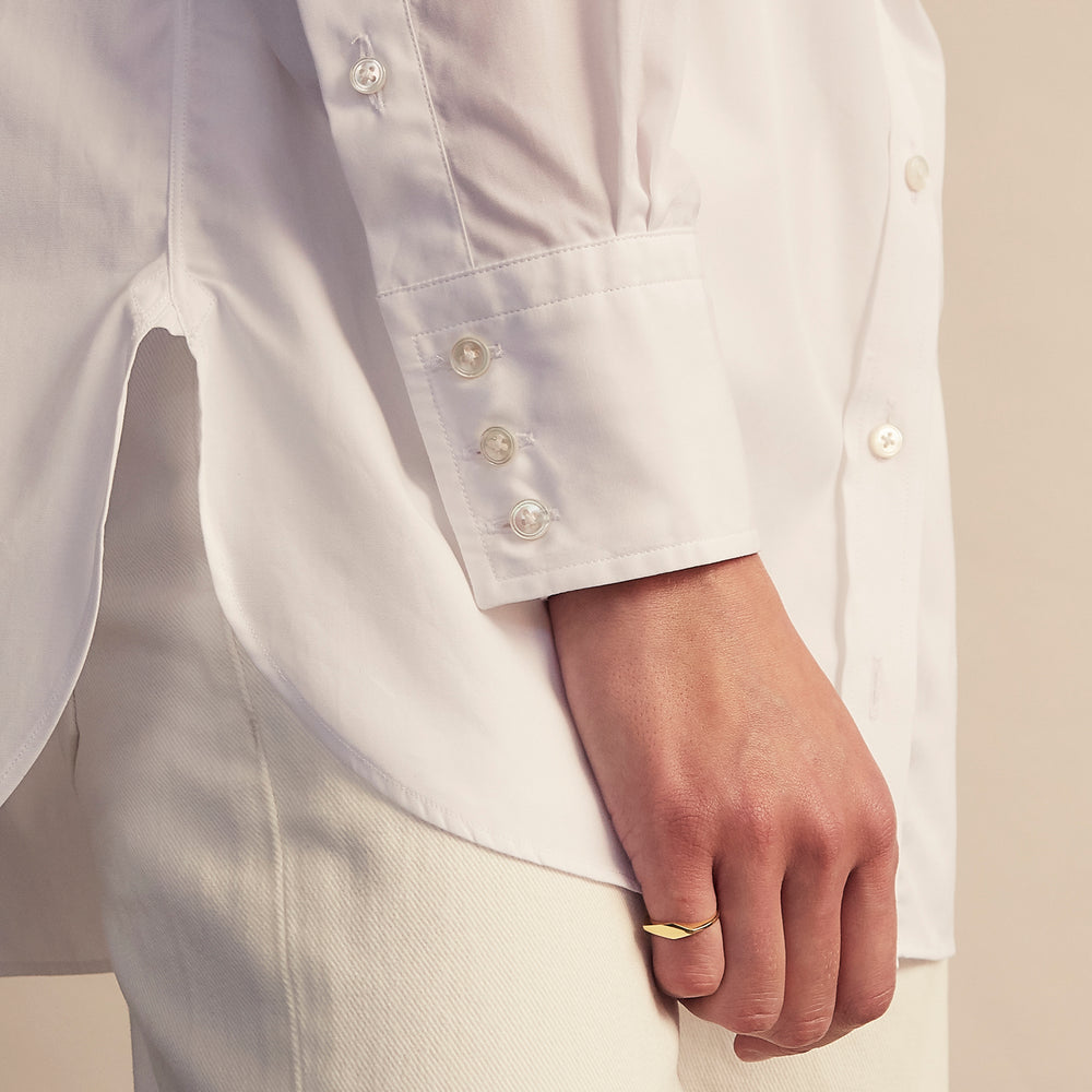 The White Cotton Lauren Shirt by Turnbull & Asser, featuring a stand collar, button-down front, and elongated body, is laid flat on a plain white background.
