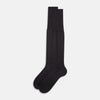 View 2 of product A single Sage Silk Long Sock by Turnbull & Asser, in black, is displayed from a side angle against a plain white background.