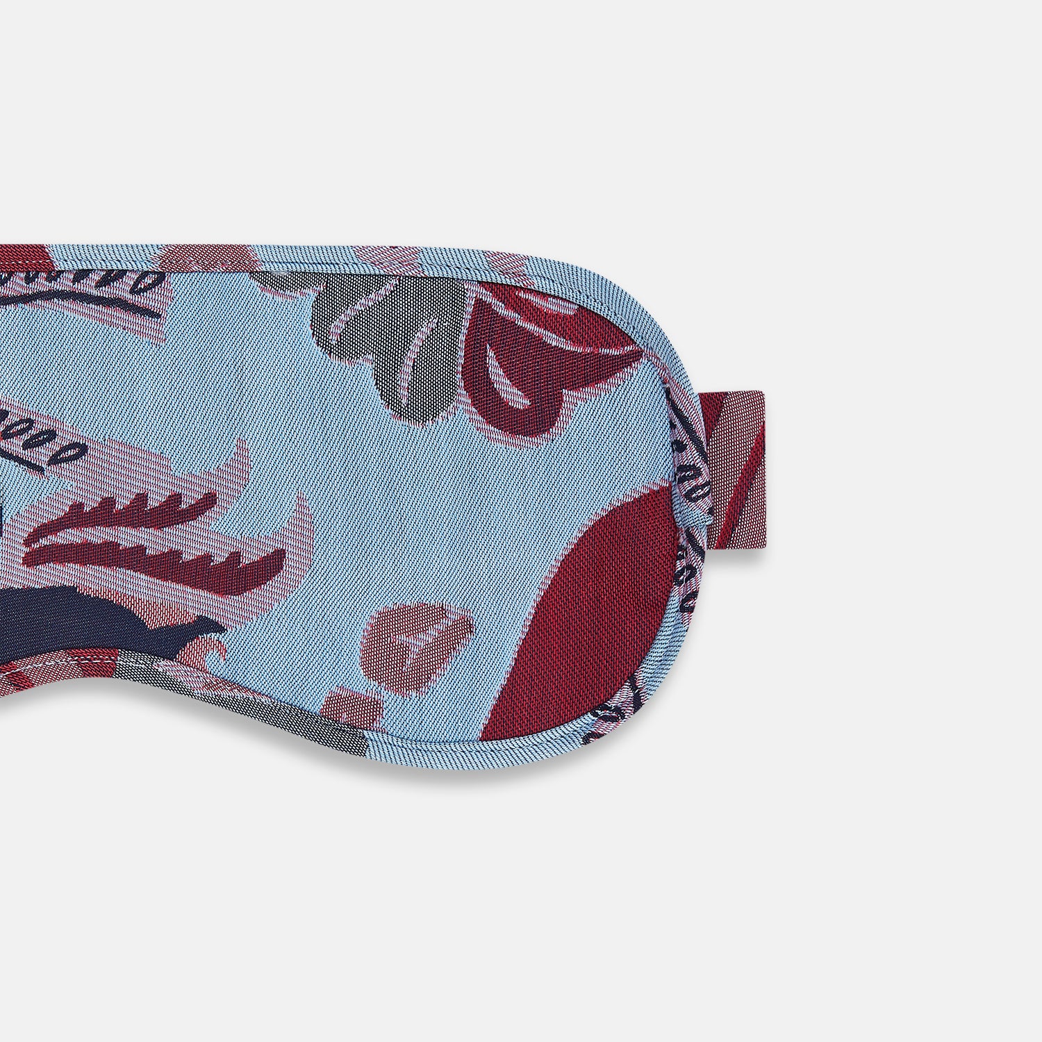 View 3 of product The Blue Bloomsbury Jacquard Cashmere Lined Sleep Mask and Bag by Turnbull & Asser features a blue and red abstract floral pattern, elastic strap, and is shown on a plain white background.