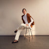 View 9 of product A person with curly hair wears the Turnbull and The Deck White Cotton Minimalist Shirt by Turnbull & Asser, paired with pants. Posed against a plain background, their minimalist silhouette is highlighted in this black and white image.