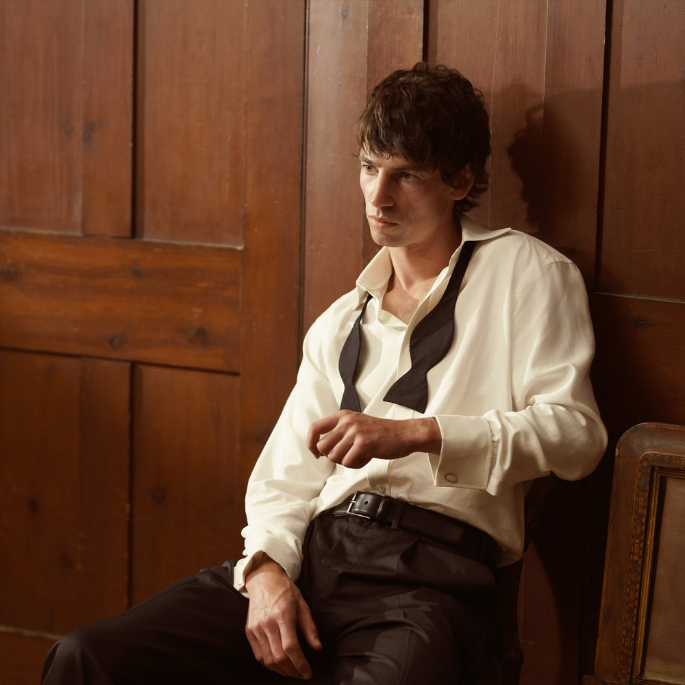 The Cream Silk Shirt by Turnbull & Asser features a T&A collar and 3-button cuffs, displayed folded on a light background—perfect for sophisticated evening wear.