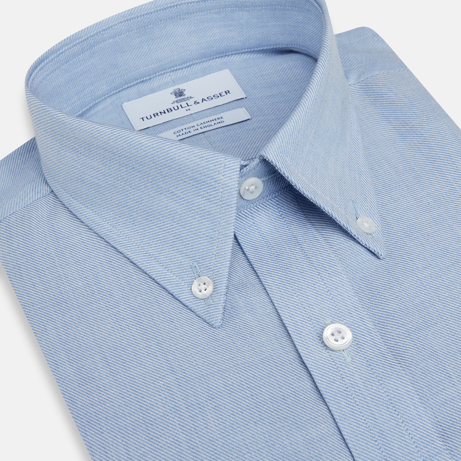 View 2 of product The Turnbull & Asser Pale Blue Cotton Cashmere Dorset Collar Richmond Shirt features long sleeves, a button-down collar, white buttons, and a chest pocket. It is neatly displayed flat on a white background.