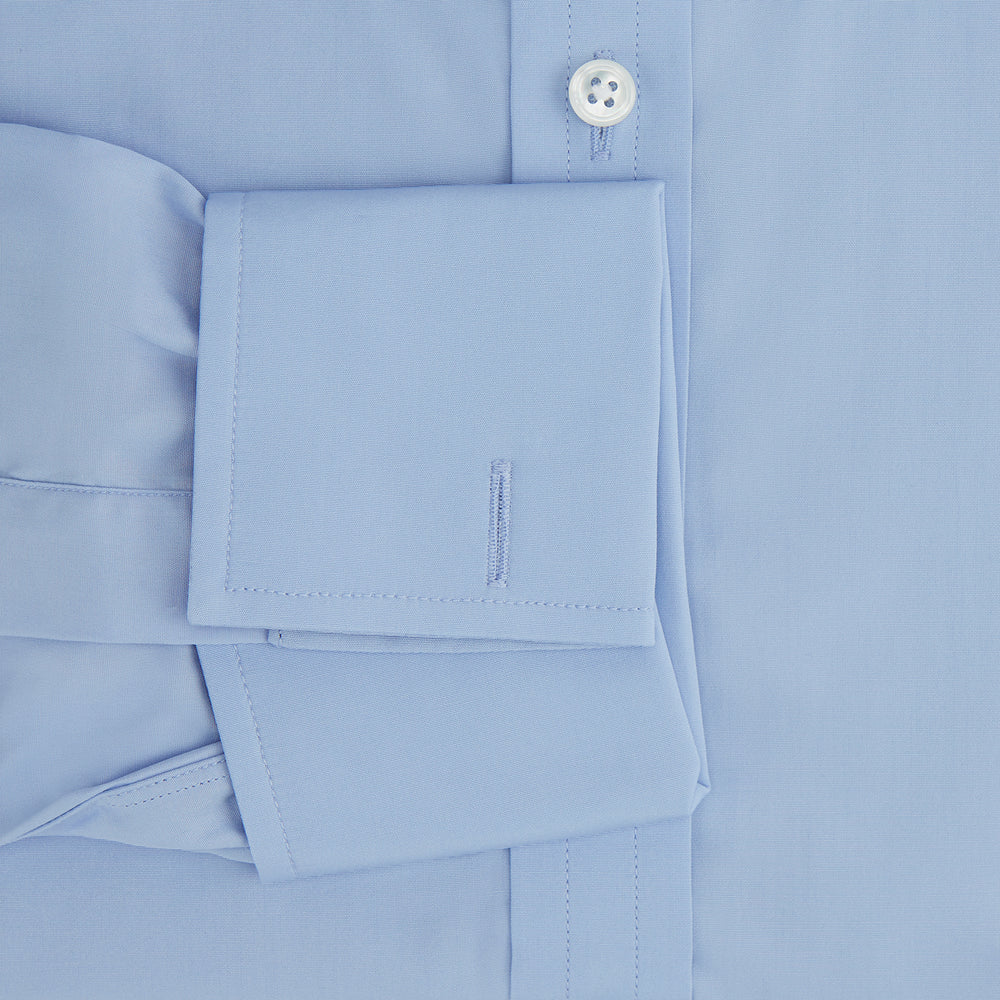 The Turnbull & Asser Blue Cotton Shirt features a T&A collar, double cuffs, and white buttons. This classic formal shirt is perfect for any gentleman and pairs effortlessly with a navy suit. Displayed on a plain white background.