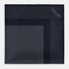 View 3 of product The Turnbull & Asser Navy and Grey Dot Silk Pocket Square features a neatly folded design with small grey dots on navy silk and a solid border, showcasing both sides of the luxurious fabric.