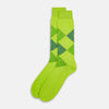 View 2 of product The Lime Check Mid-Length Sock by Turnbull & Asser features a green and yellow argyle pattern with a ribbed cuff, crafted from comfortable cotton material, and is shown on a plain light background.