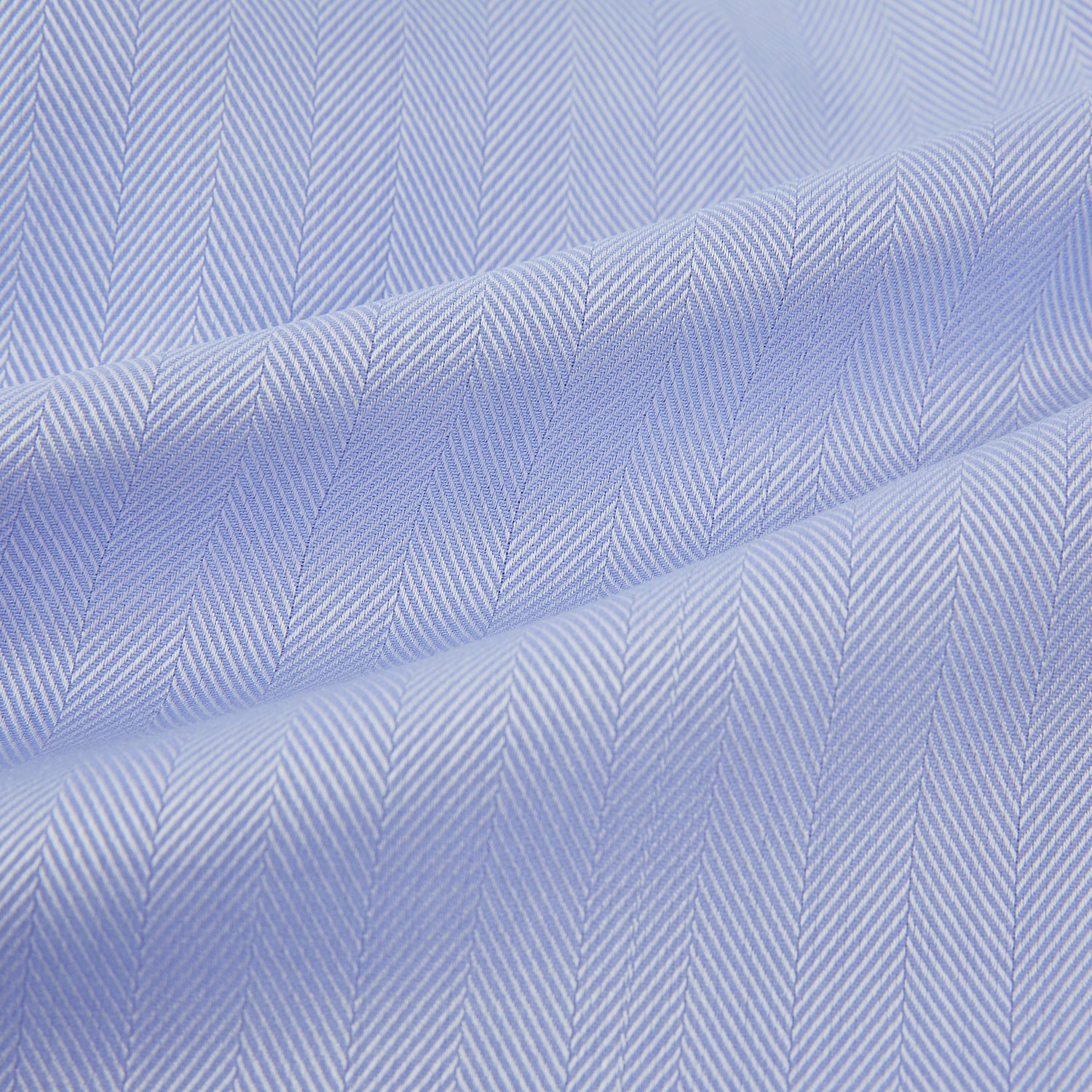View 6 of product The Turnbull & Asser BLUE HERRINGBONE TAILORED FIT SHIRT WITH KENT COLLAR features long sleeves and buttoned cuffs, offering a timeless formal look in a classic light blue herringbone fabric, laid flat on a white background.