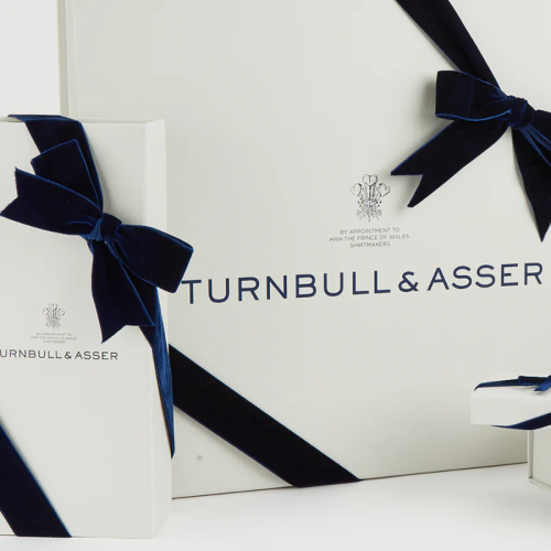 GiftWrapping by Gift—elegant white boxes adorned with dark blue velvet ribbons and bows, featuring the Gift logo and text on the packaging.