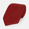 View 1 of product The Turnbull & Asser Red and Navy Polka Dot Silk Tie is elegantly rolled on a white background, highlighting classic British craftsmanship.
