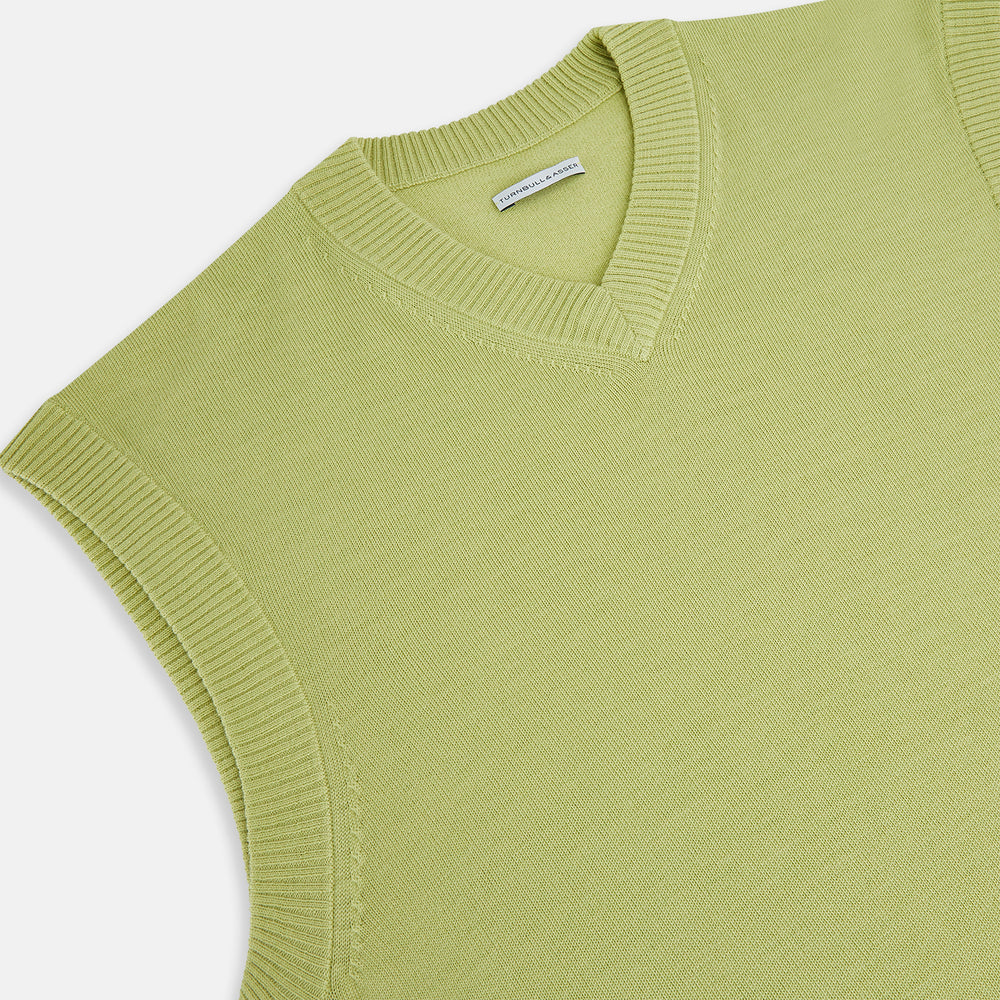 The Turnbull & Asser Melon Green Fine Merino V-Neck Vest, sleeveless with ribbed edges, is shown on a white background—ideal for layering or wearing alone as an elegant gentleman's piece.