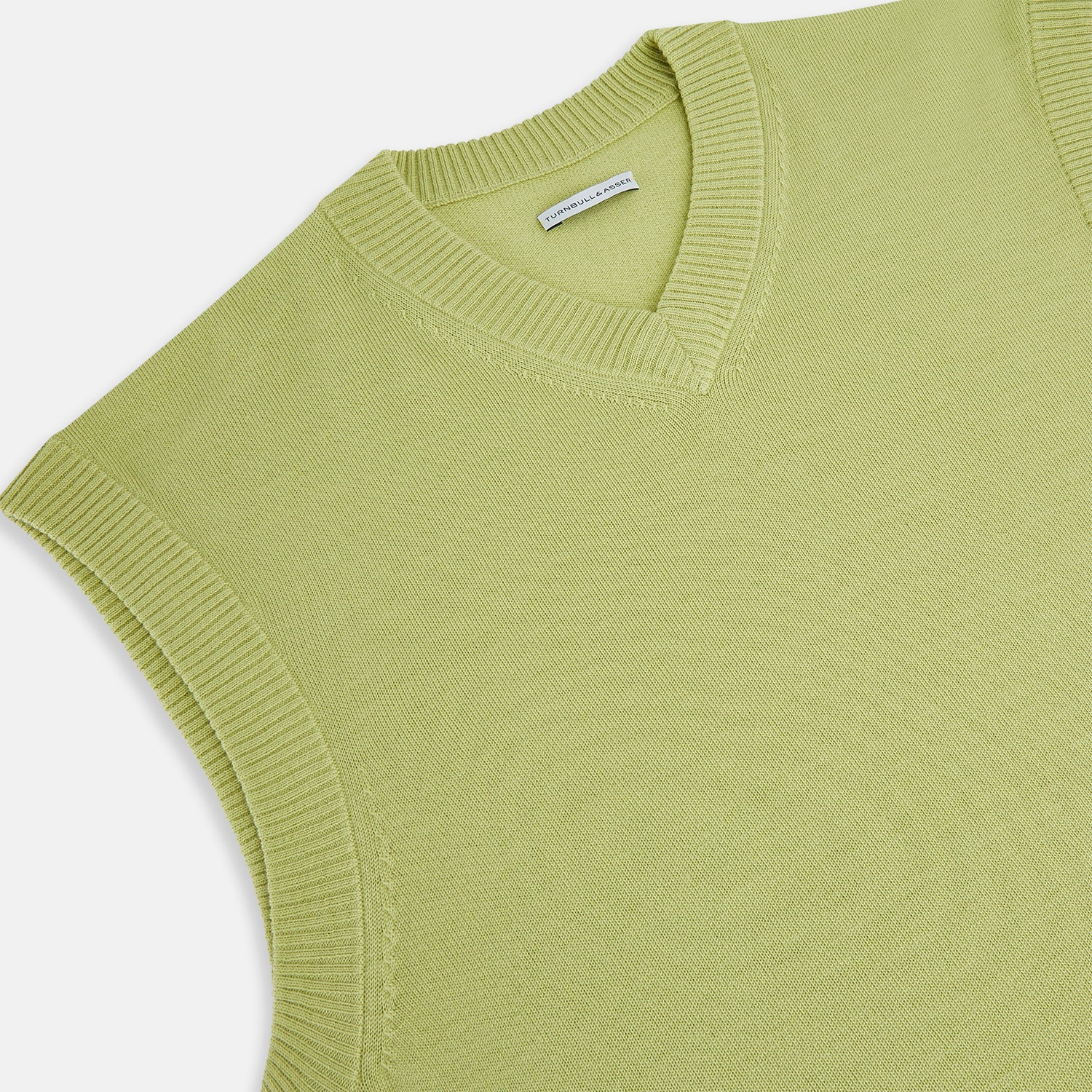 View 2 of product The Turnbull & Asser Melon Green Fine Merino V-Neck Vest, sleeveless with ribbed edges, is shown on a white background—ideal for layering or wearing alone as an elegant gentleman's piece.
