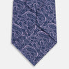 View 3 of product The Turnbull & Asser Lilac Paisley Silk Tie, crafted in England, features a blue paisley pattern on a lilac background and is shown rolled up against a white surface.