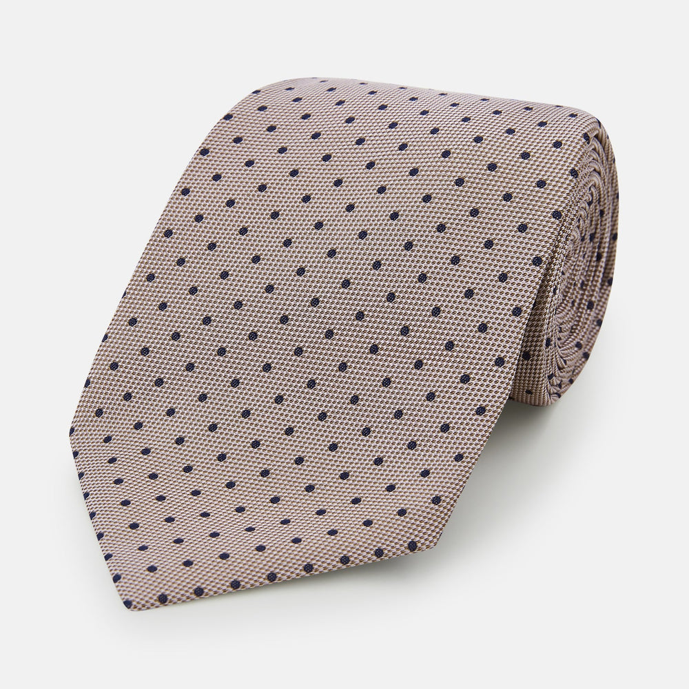 The Turnbull & Asser Navy and Lilac Micro Dot Silk Tie, featuring subtle micro dots, is the perfect refined accessory for smart outfits, shown rolled up against a plain white background.