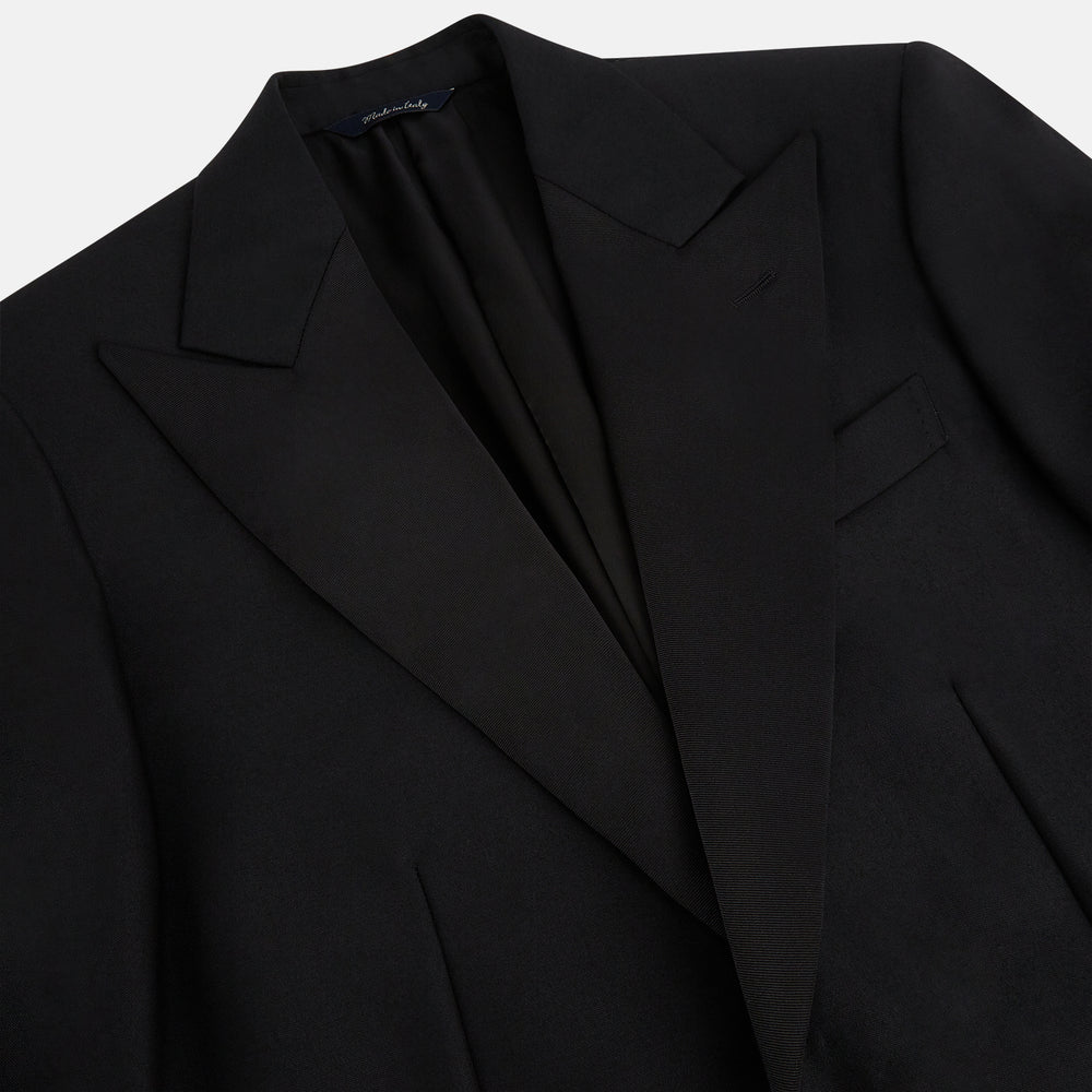 The Turnbull & Asser Black Single Breasted Dinner Suit, with satin lapels and matching trousers, is elegantly folded and displayed on a plain white background.