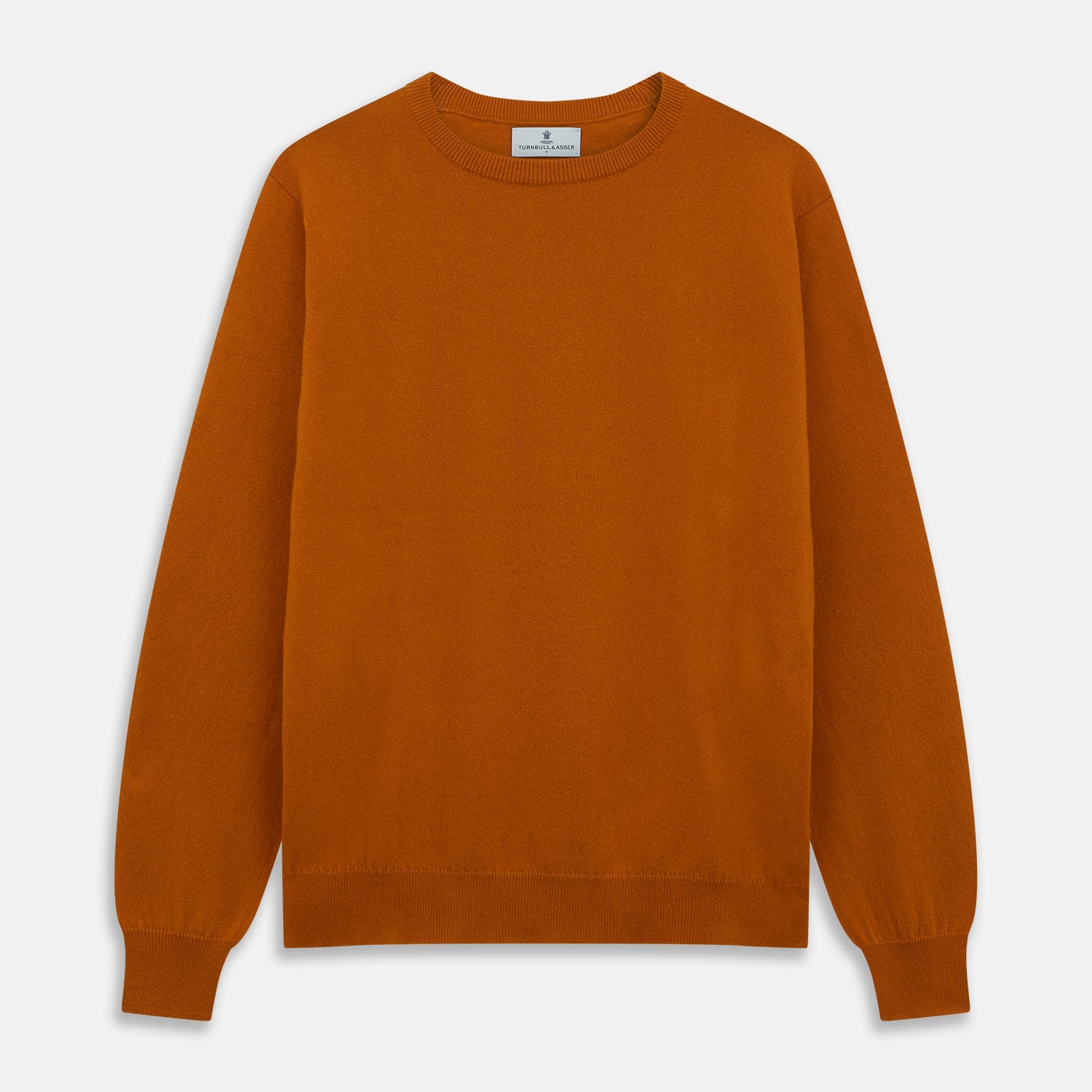 View 1 of product The Turnbull & Asser Rust Glenn Crew Neck Jumper is a plain, long-sleeved Scottish knitwear piece with ribbed cuffs and hem, shown laid flat on a white background.