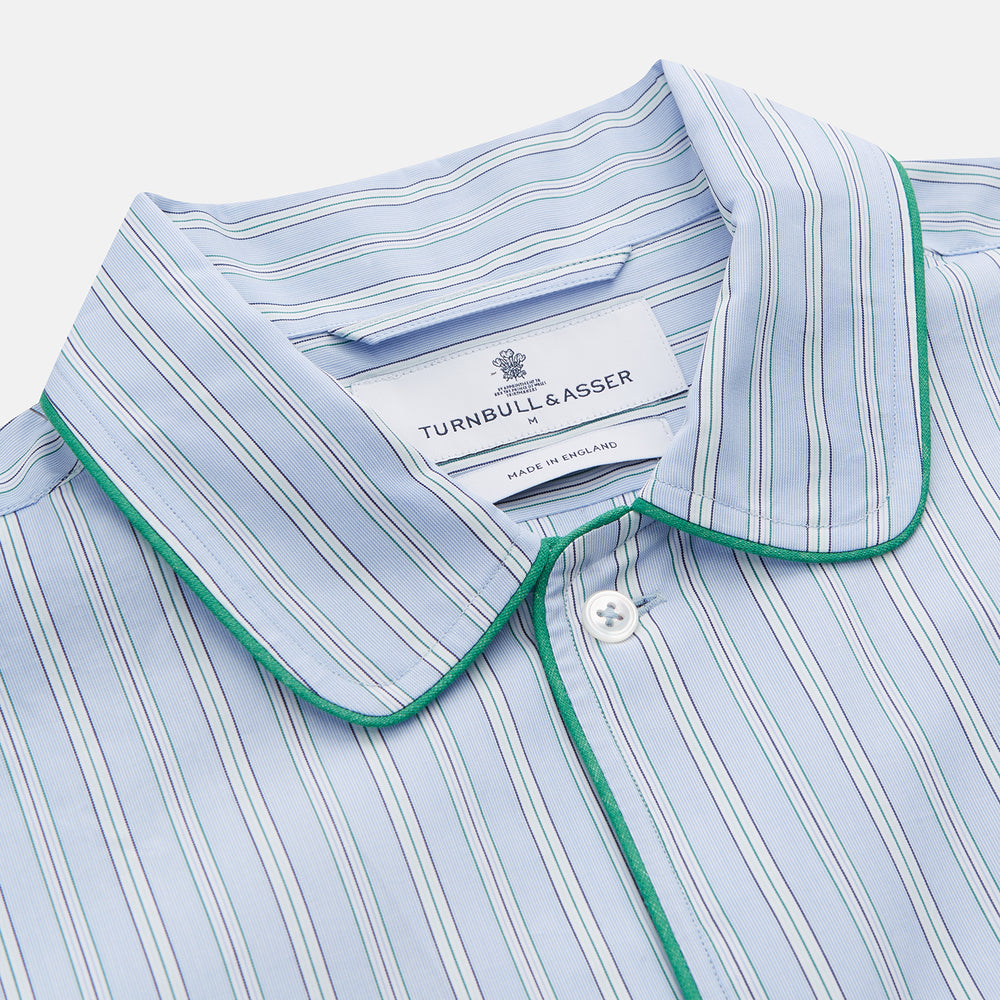 The Turnbull & Asser Blue and Green Stripe Poplin Cotton Nightshirt features long sleeves, a rounded hem, front pocket, green-trimmed collar and pocket, and front buttons—ideal men's nightwear for any season.