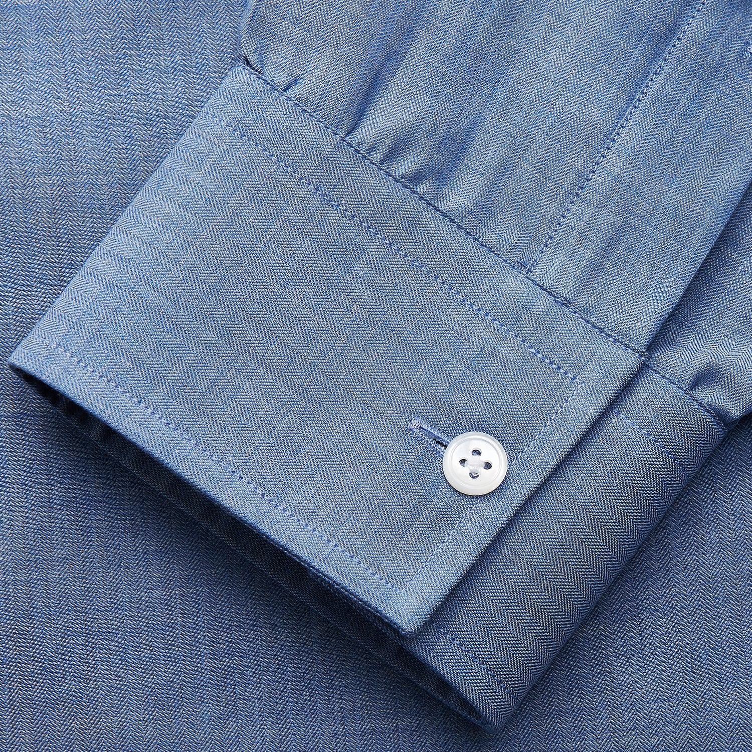 View 2 of product The Turnbull & Asser Blue Cotton Weekend Fit Blake Shirt features a light blue color, long sleeves, stand collar, white buttons, and a curved hem—ideal for casual weekends. Laid flat on a white background.