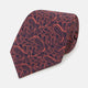 A rolled-up Turnbull & Asser Orange Paisley Silk Tie, featuring an elegant pattern, is displayed against a plain white background.
