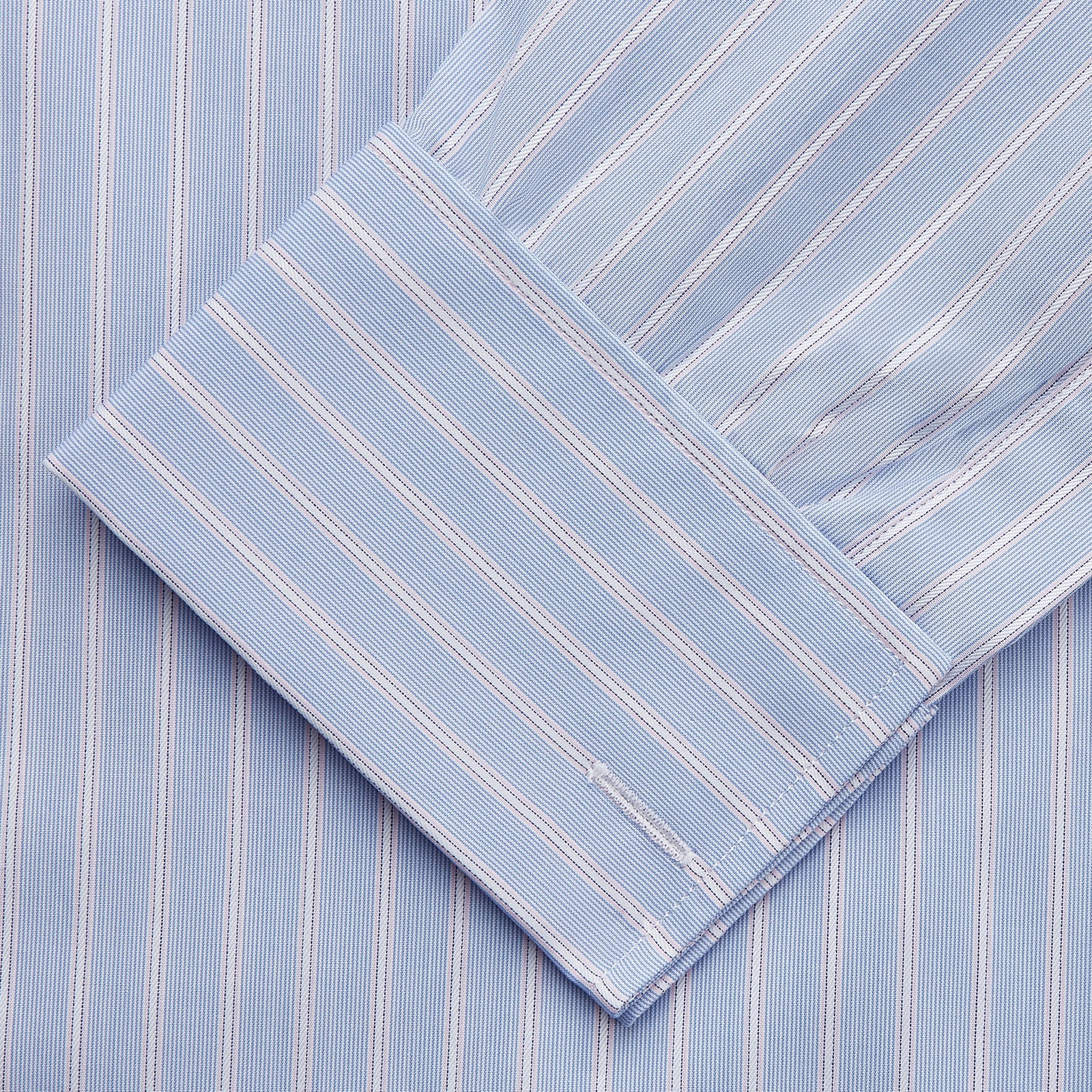 View 3 of product The Turnbull & Asser Blue Multi Stripe Cotton Regular Fit Whitby Shirt features white vertical stripes, long sleeves, button-down front, pointed collar, and buttoned cuffs, shown laid flat on a white background.