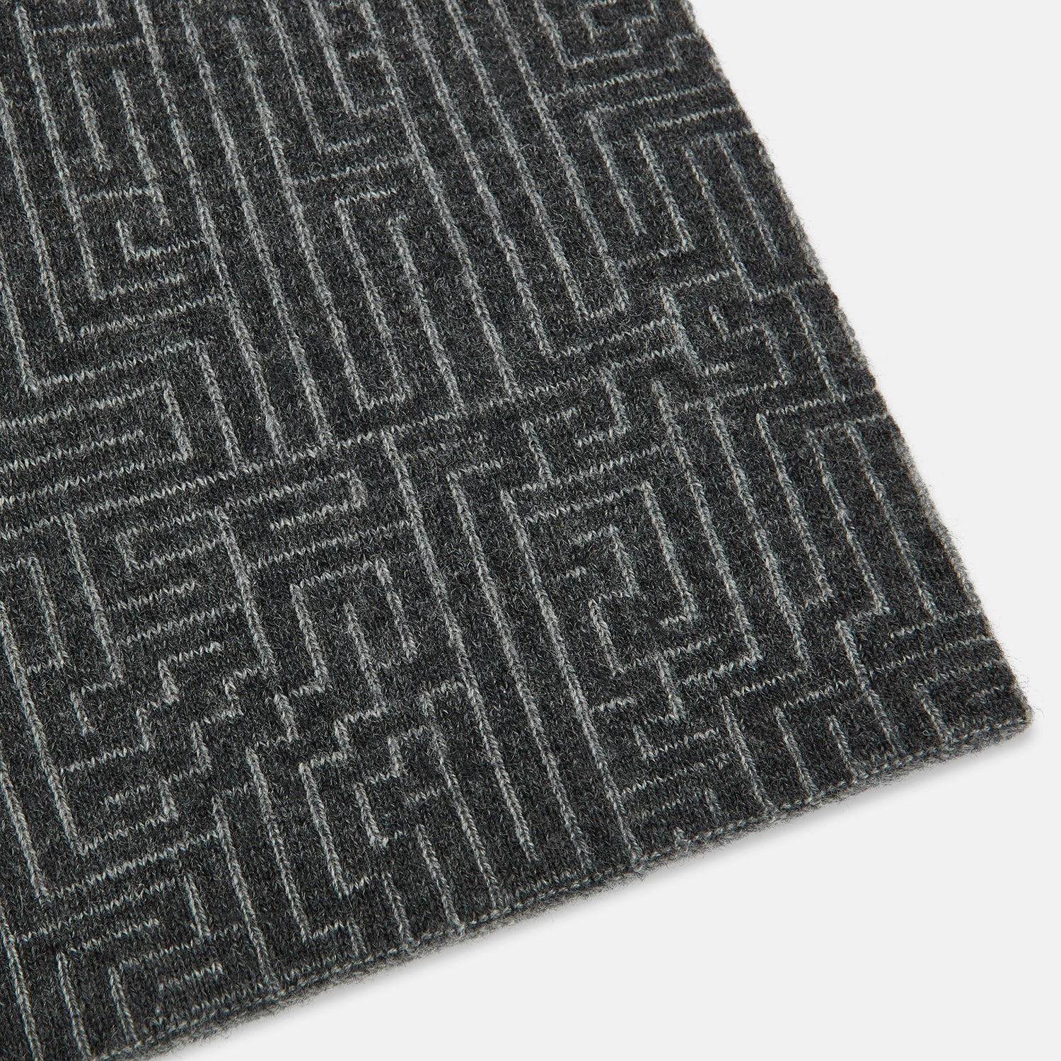 View 2 of product The Turnbull & Asser Grey Fretwork Cashmere Knitted Scarf showcases a geometric maze-like pattern in gray, elegantly looped with draped ends—an essential accessory set against a plain white background.