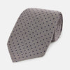 View 1 of product The Turnbull & Asser Navy and Lilac Micro Dot Silk Tie is shown rolled up on a white background, featuring a refined pattern of small lilac dots on navy silk.