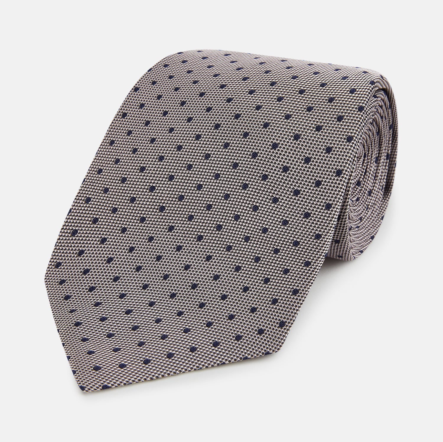 View 1 of product The Turnbull & Asser Navy and Lilac Micro Dot Silk Tie is shown rolled up on a white background, featuring a refined pattern of small lilac dots on navy silk.
