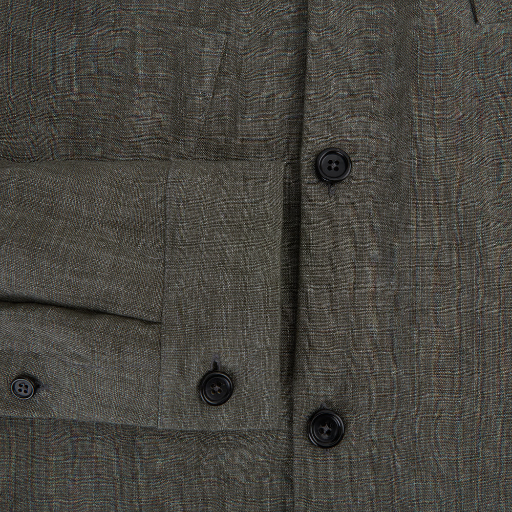 The Olive Linen Holland Shacket by Turnbull & Asser is a lightweight olive button-up jacket in Irish linen with a collar, two front pockets, one chest pocket, and slanted hem pockets—ideal outerwear shown on a plain white background.