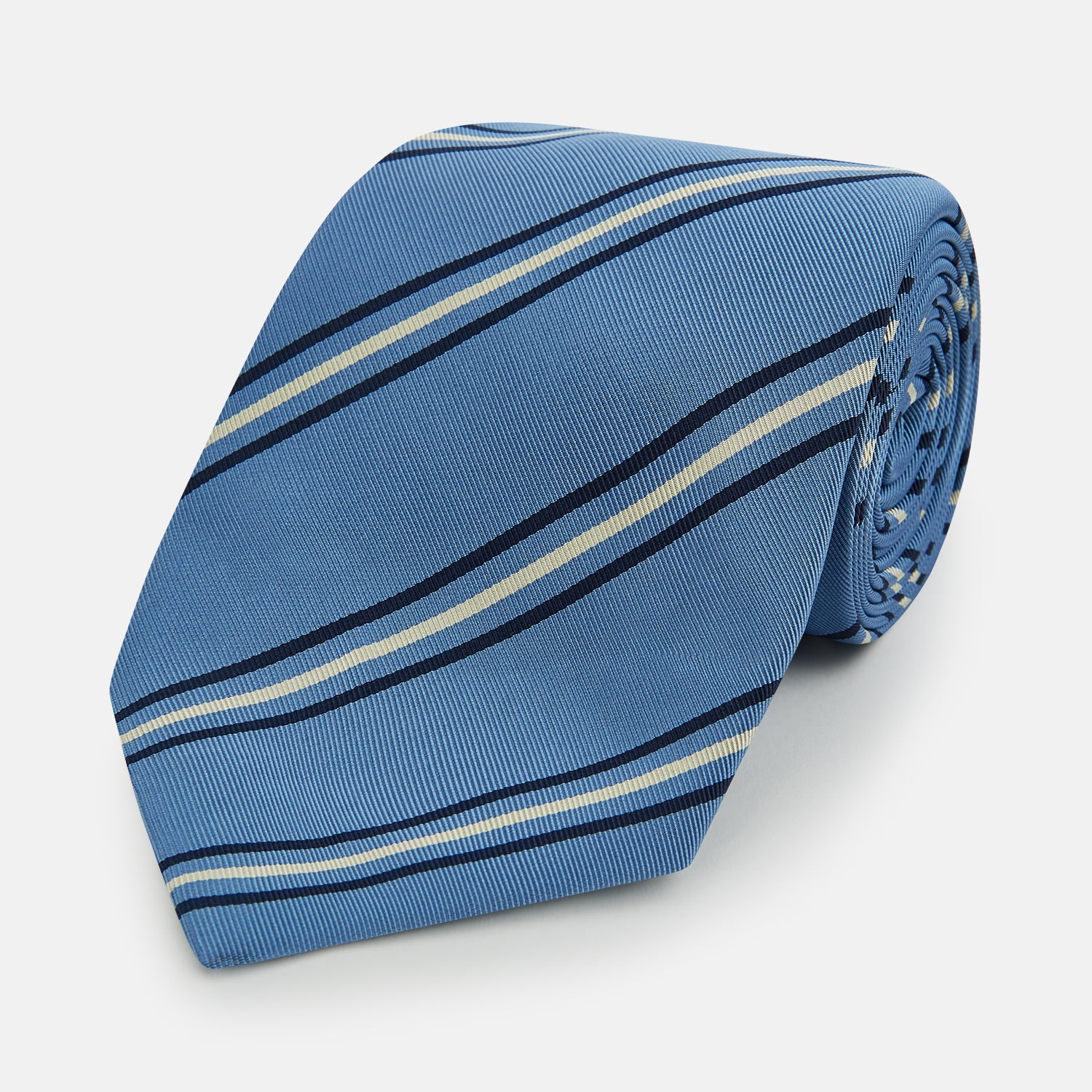 View 1 of product The Blue Multi Stripe Silk Blend Tie by Turnbull & Asser features diagonal navy and light beige stripes, shown rolled up on a white background—a timeless formal accessory.