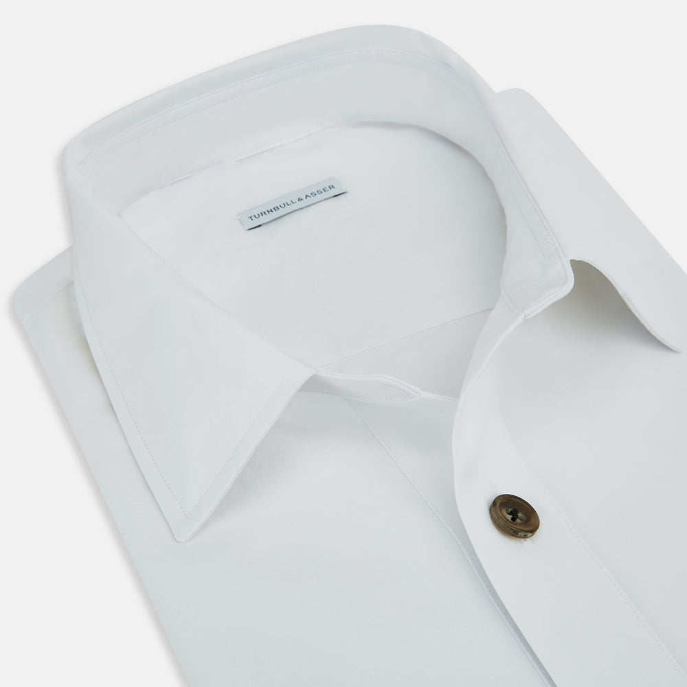The White Hyde Overshirt by Turnbull & Asser is crafted from sanforised cotton with a left chest pocket and dark buttons—offering a sharp, casual blazer alternative. Shown laid flat on a white background.