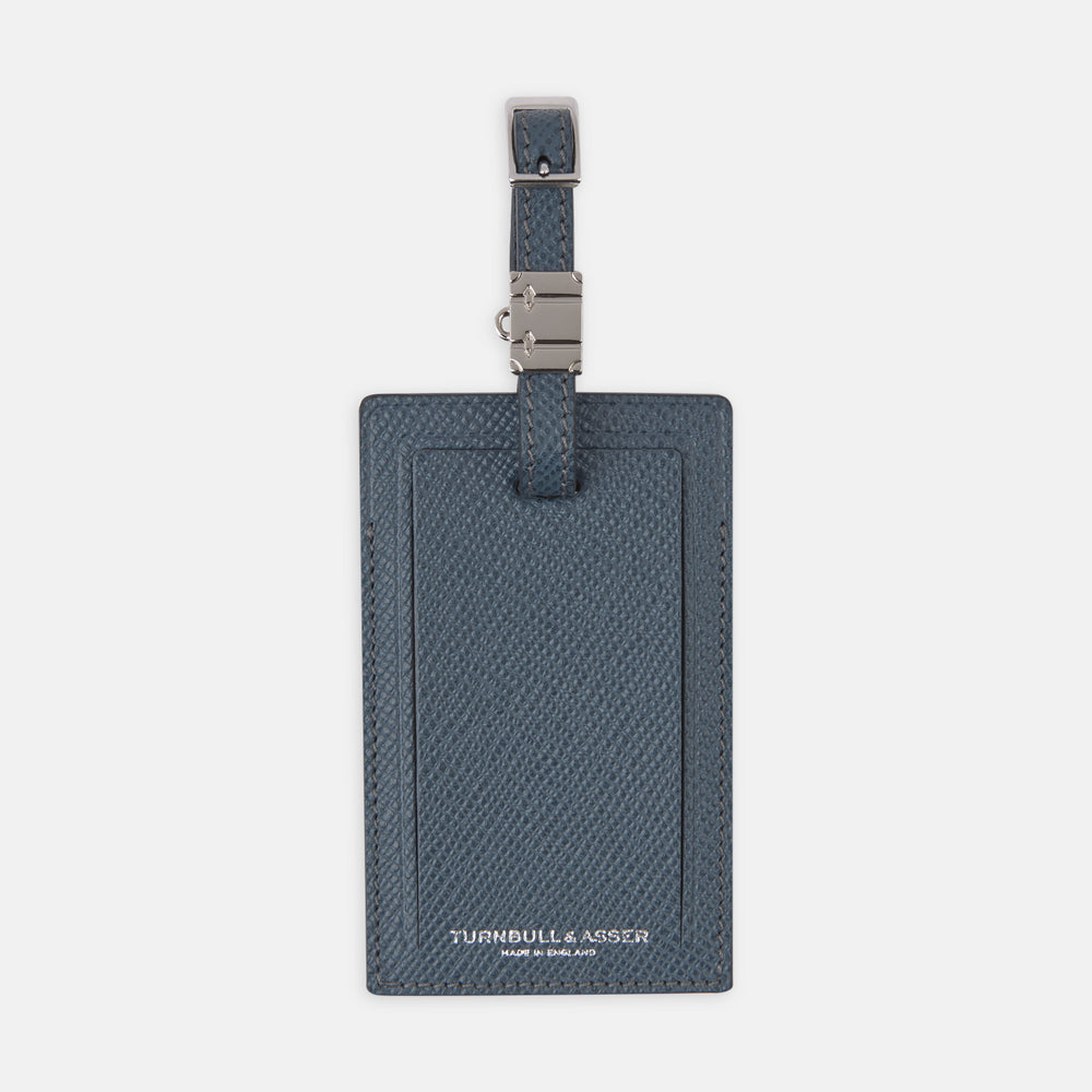 The Blue Leather Luggage Tag by Turnbull & Asser features textured leather, a metal buckle and strap, and displays the logo with "Made in England" printed in white at the bottom.