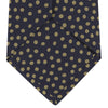 View 4 of product The Turnbull & Asser Navy and Gold Paint Spot Silk Tie features evenly spaced gold spots on classic navy silk, rolled and displayed on a plain white background—ideal for complementing your favorite office shirt.