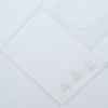 View 4 of product A neatly folded White Sea Island Quality Cotton Twill Shirt by Turnbull & Asser, featuring a T&A collar and 3-button cuffs, is displayed on a light grey background with a label visible inside the collar.