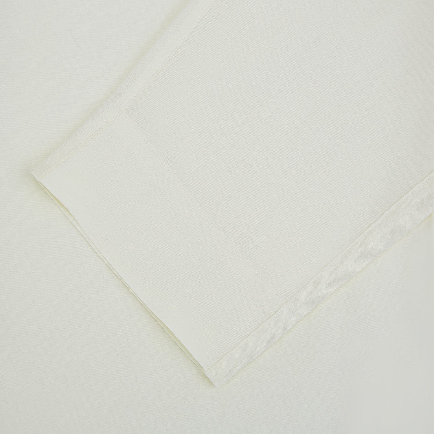 View 3 of product The Turnbull & Asser Cream Silk Pyjama Set, shown laid flat on a white background, features a long-sleeve button-up top with a chest pocket and matching pants with an elastic drawstring waist—ideal for comfortable loungewear.