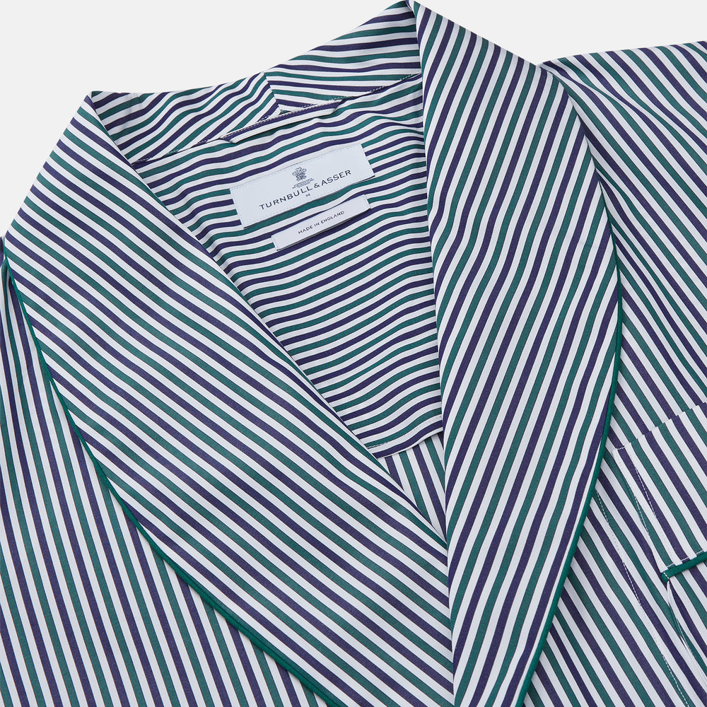 The Turnbull & Asser Green and Blue Stripe Cotton Arnold Gown features long sleeves, a knee-length cut, a shawl collar, front pockets, and an elegant wrap belt at the waist.