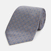 View 1 of product The Turnbull & Asser Silver and Pale Blue Multi Dot Silk Tie features elegant small dots on light brown silk, ideal for modern office wear, shown rolled up against a white background.