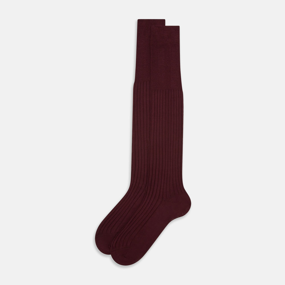 A single Burgundy Long Sock by Turnbull & Asser is shown on a white background, angled to display its over-the-calf length, fitted shape, and ribbed texture along the calf and foot.