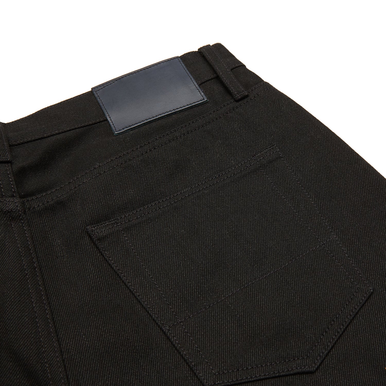 View 2 of product A pair of Turnbull & Asser Black Italian Selvedge Denim Jeans with a five-pocket design, button closure, and cuffed hems, displayed flat on a white background.