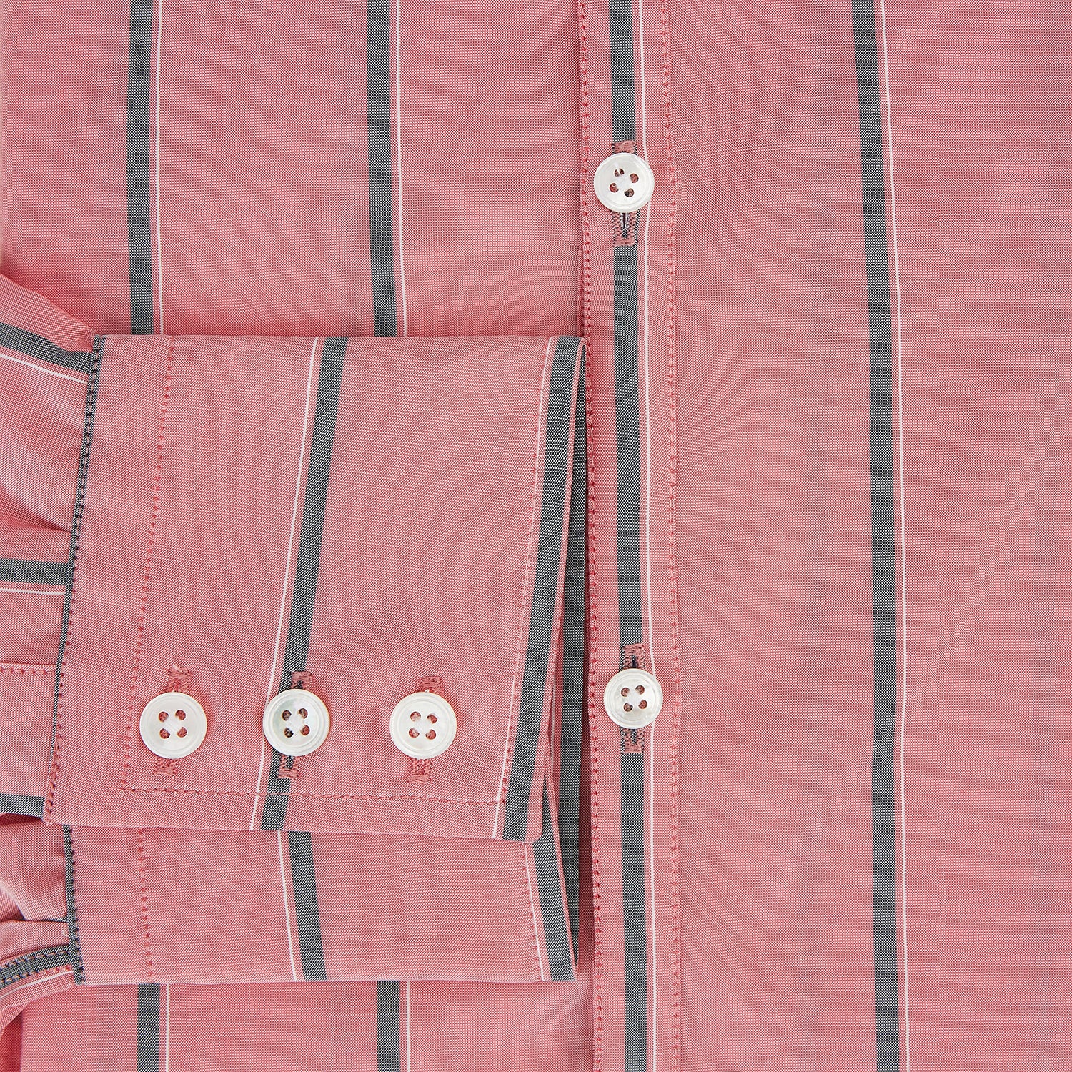 View 4 of product The Coral Pink Track Stripe Westminster Shirt by Turnbull & Asser features vertical navy and white stripes, a tailored fit, pointed collar, and buttoned cuffs—is displayed laid flat on a white background.