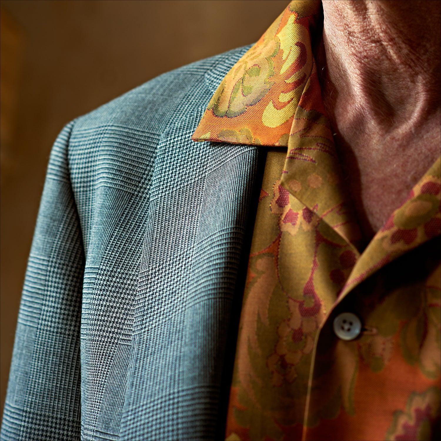 View 3 of product The Orange & Ochre Tapestry Weave Cotton Holiday Fit Shirt by Turnbull & Asser is a short-sleeve, revere collar shirt featuring a yellow and brown floral and leaf pattern on an orange base, finished with white buttons.