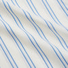 View 5 of product A man with short brown hair stands against a beige background in a Turnbull & Asser Blue and Off-White Stripe Cotton Weekend Fit Finch Shirt, featuring vertical stripes and a Derby collar, paired with dark pants. One hand is in his pocket; he has a neutral expression.