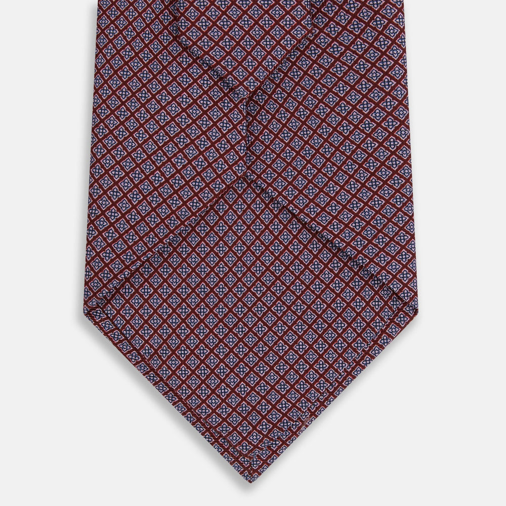 The Turnbull & Asser Indies Red Floral Square-Print Silk Tie is shown rolled up, highlighting its red floral square pattern against a plain white background.