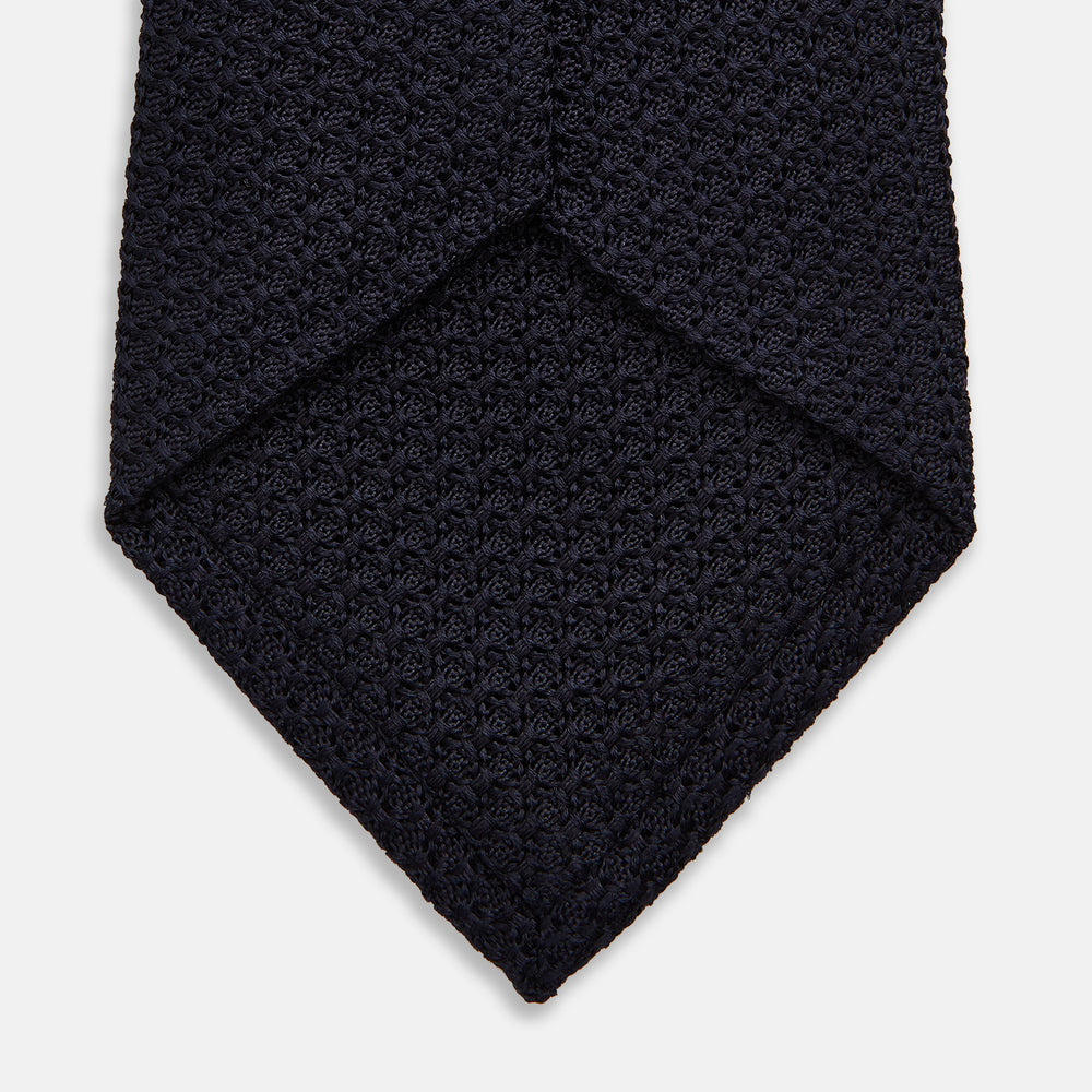The GRENADINE NEW NAVY TIE by Turnbull & Asser features a dark navy blue woven texture, making it the perfect accessory for refined looks. Displayed against a plain white background.