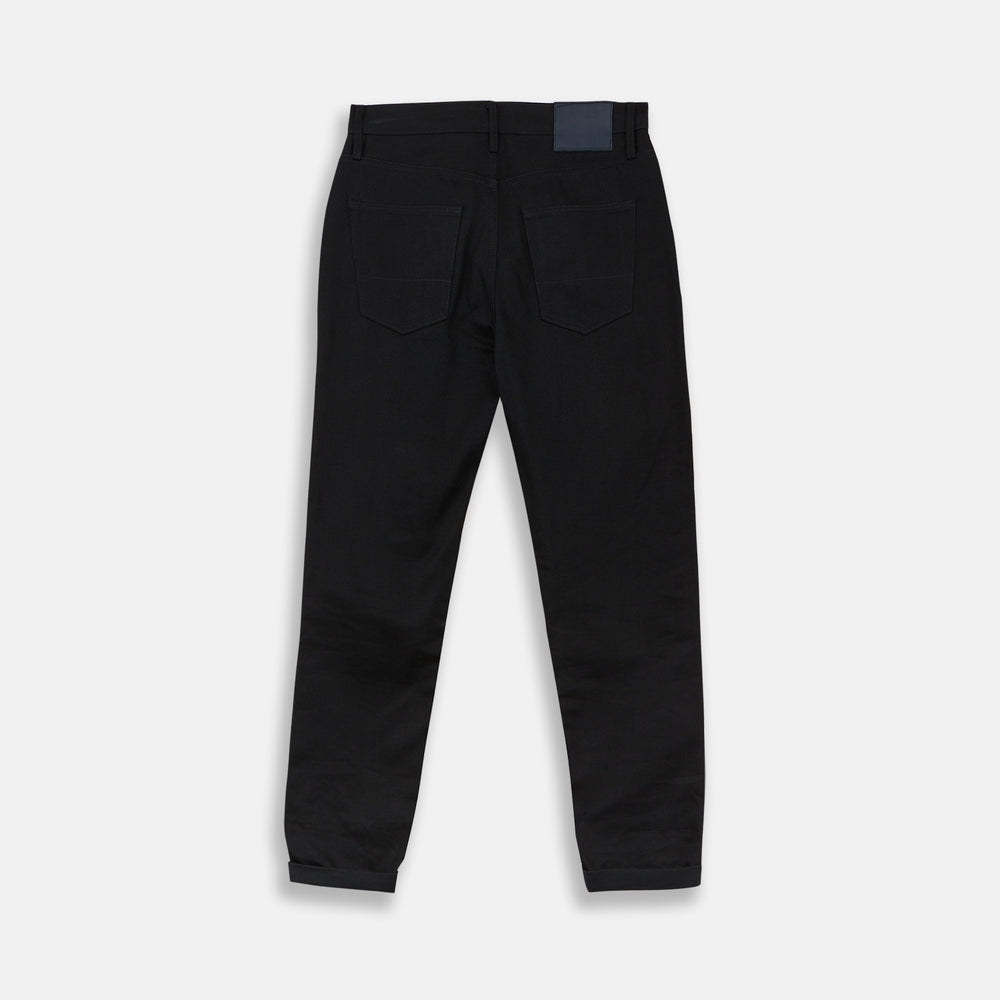 A pair of Turnbull & Asser Black Italian Selvedge Denim Jeans with a five-pocket design, button closure, and cuffed hems, displayed flat on a white background.