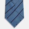 View 3 of product The Turnbull & Asser Blue and Navy Blazer Stripe Silk Tie features diagonal navy stripes and is shown rolled up against a plain white background.