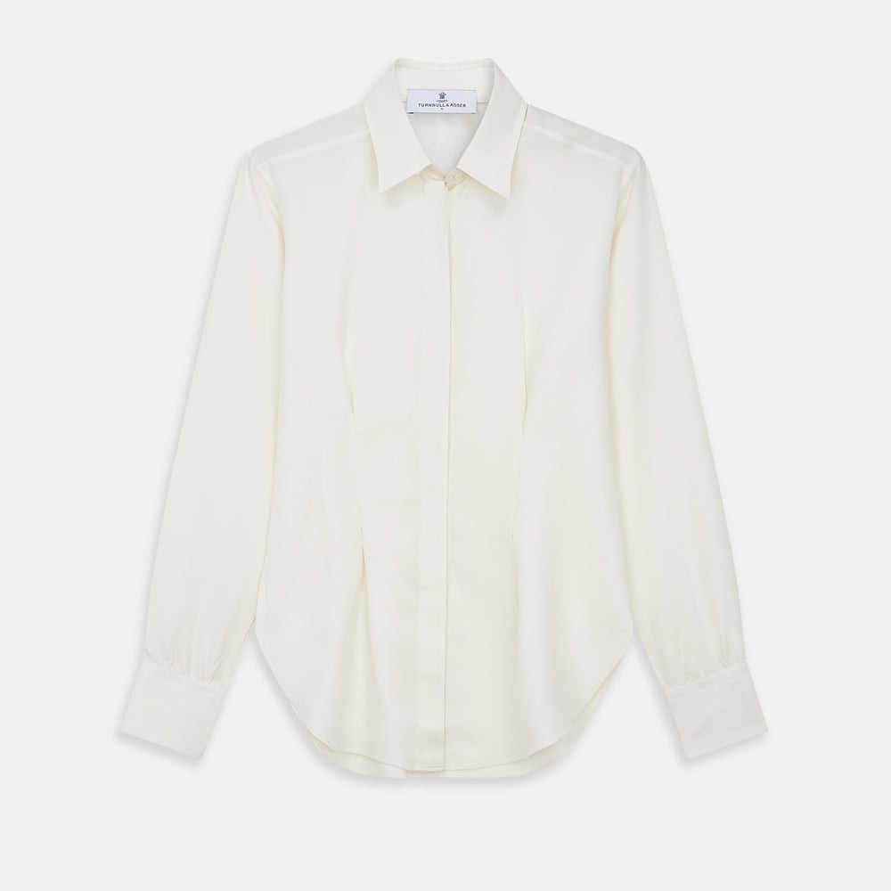 The Cream Silk Tailored Bianca Shirt by Turnbull & Asser features long sleeves, a pointed collar, and curved hem in soft-touch peace silk with a tailored fit. Shown laid flat on a white background.